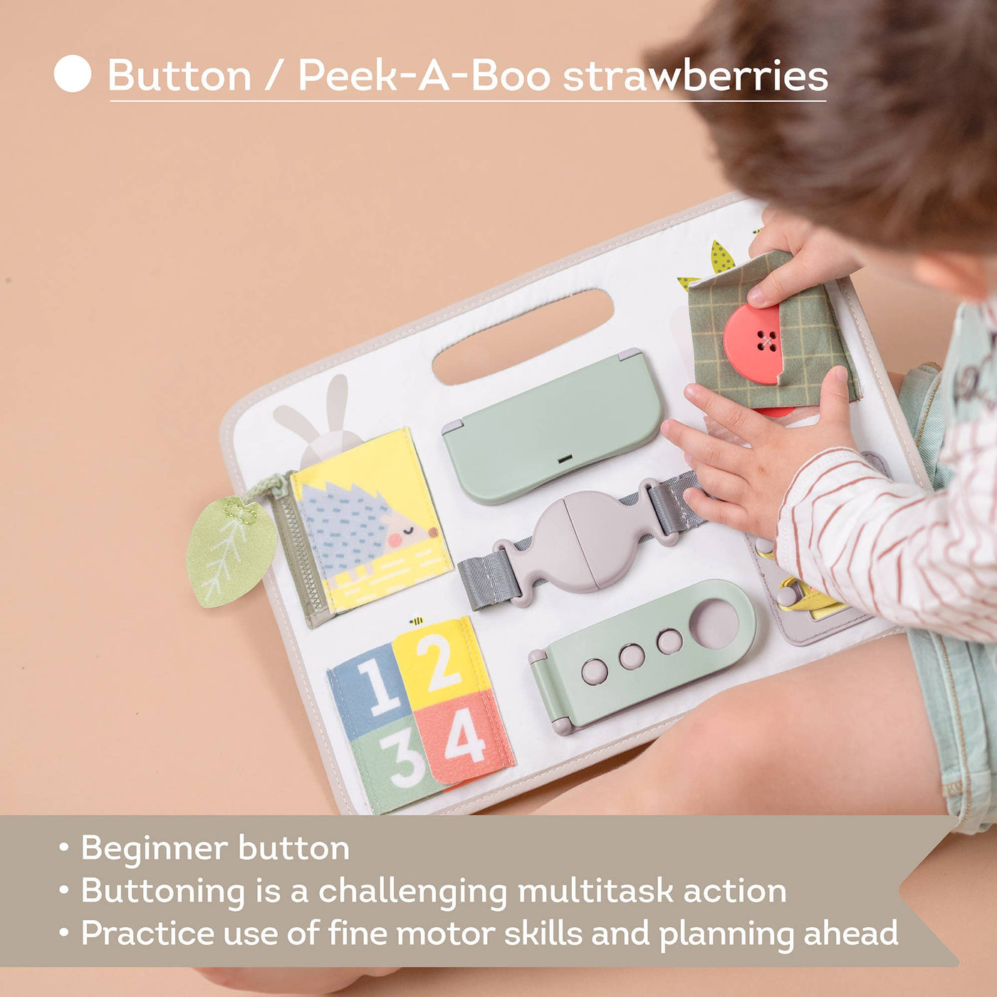 Child playing with a educational toy featuring buttons and a peek-a-boo 